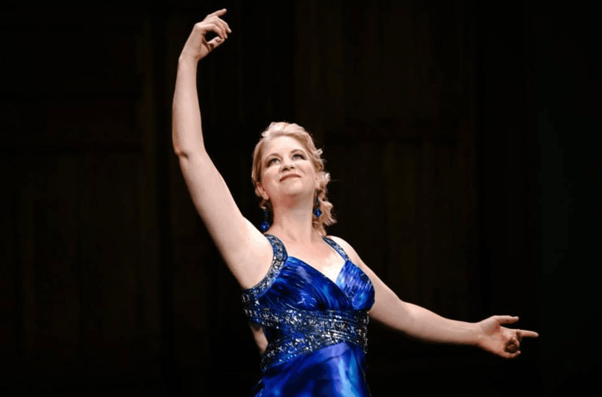 In a blue dress Maria Drost demonstrates to her Voice Academy students skills to be Singers For Weddings